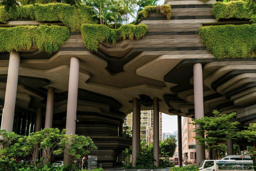 Modern urban building with lush greenery and unique geometric design, showcasing futuristic architecture.
